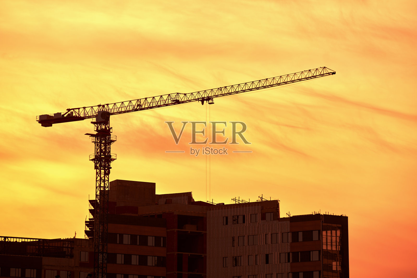 工地上有新楼和吊车,傍晚黄阴天背景,阳光,背光照片摄影图片