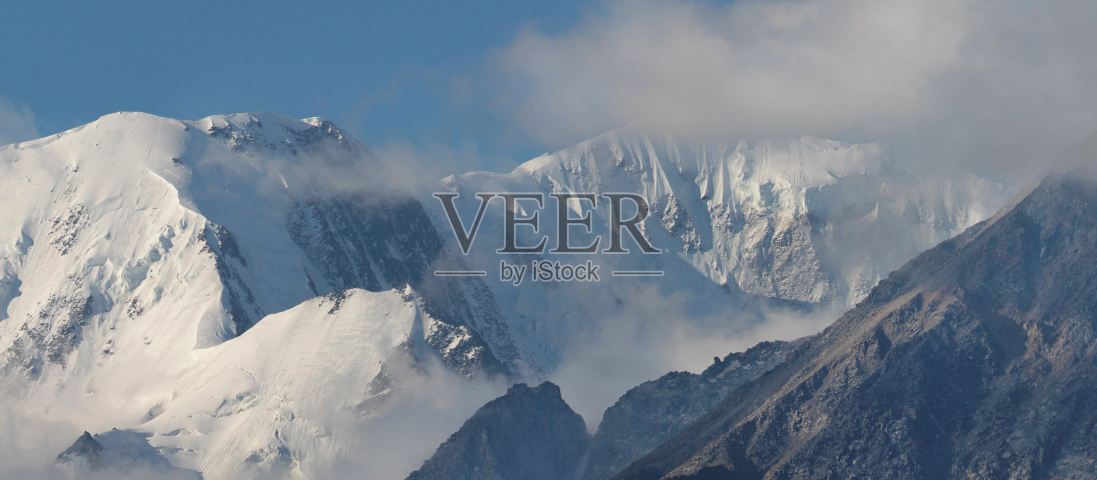 雪皑皑的山峰高耸入云。在山上旅行,爬山。照片摄影图片