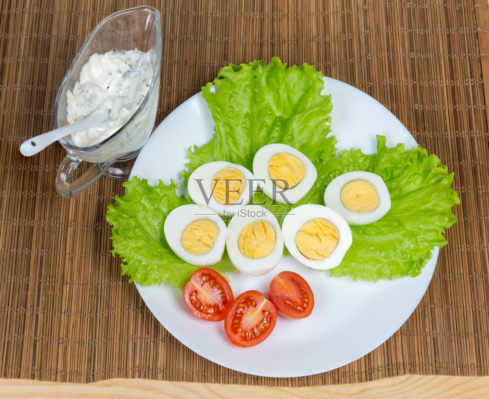两半煮鸡蛋加莴苣和番茄,俯视图照片摄影图片