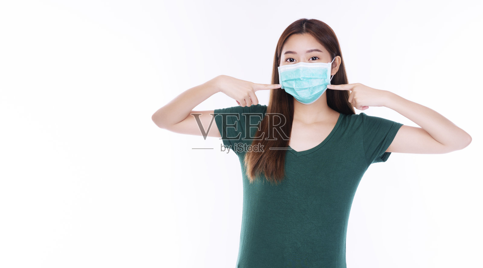 年轻女子用手指指着安全医用口罩,防止吸入空气中的细菌或病毒疾病和空气污染问题,将鼻子置于孤立的白色背景上。卫生保健的概念照片摄影图片