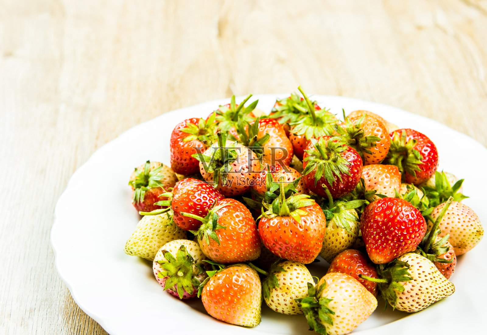 盘子里的一堆草莓照片摄影图片