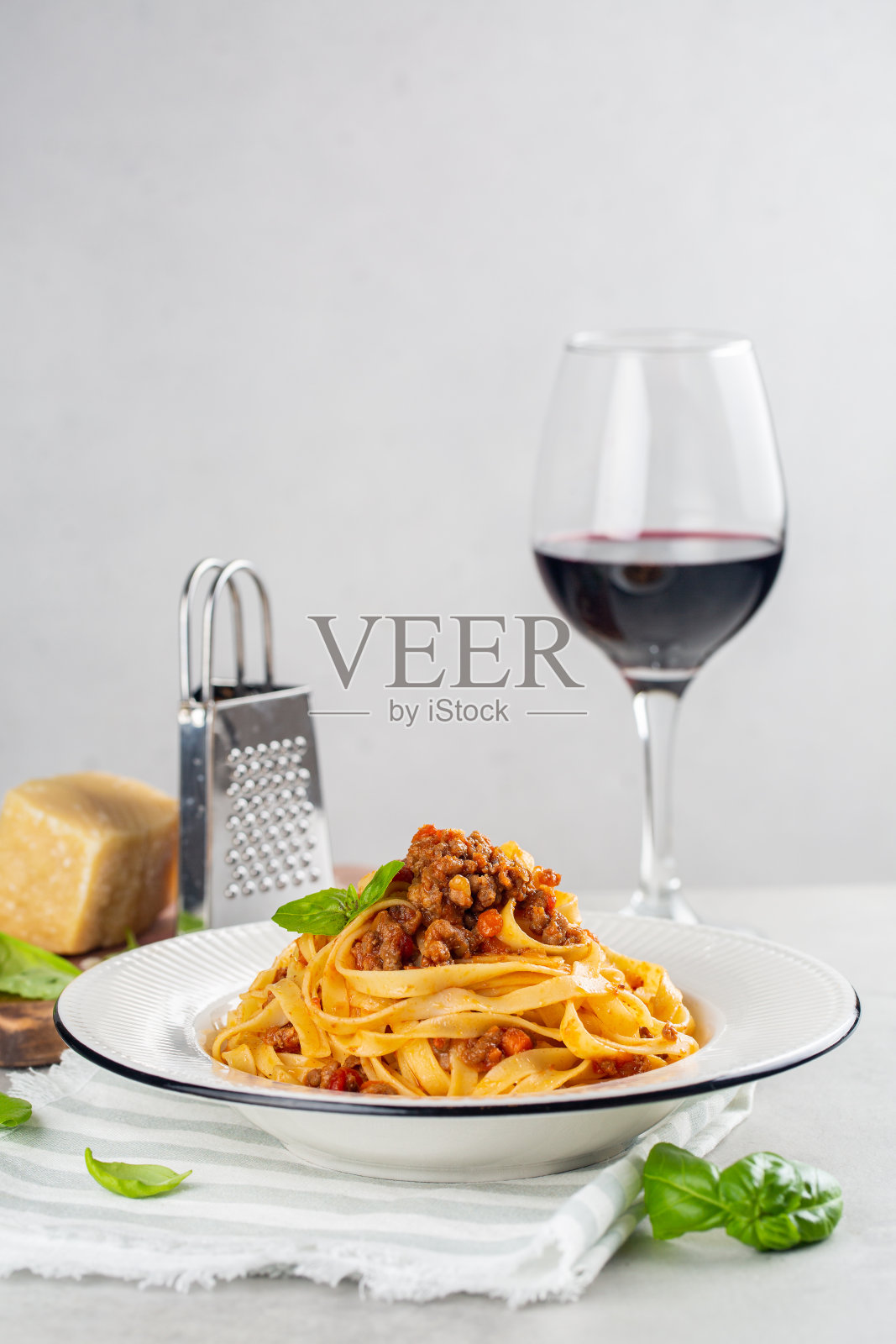 意大利蛋面加肉酱和一杯红酒。照片摄影图片
