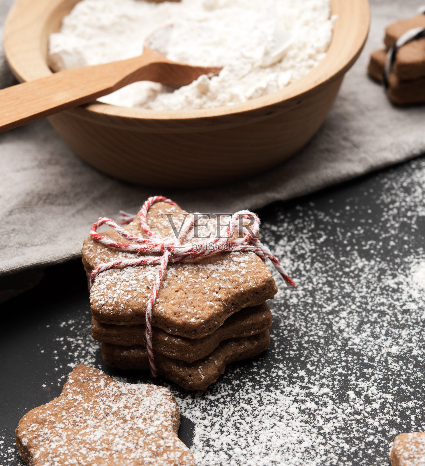 烤星形姜饼,洒上糖粉,放在黑色的桌子上照片摄影图片