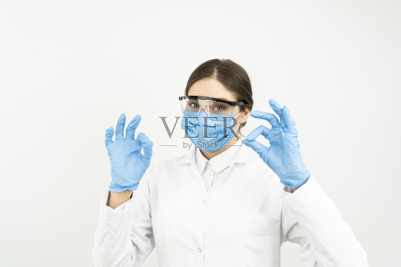 医生、感染学家、研究人员和新冠病毒概念。满意的年轻女医生在研究病毒、发现疫苗、翘起大拇指、戴口罩和手套等方面取得良好效果照片摄影图片