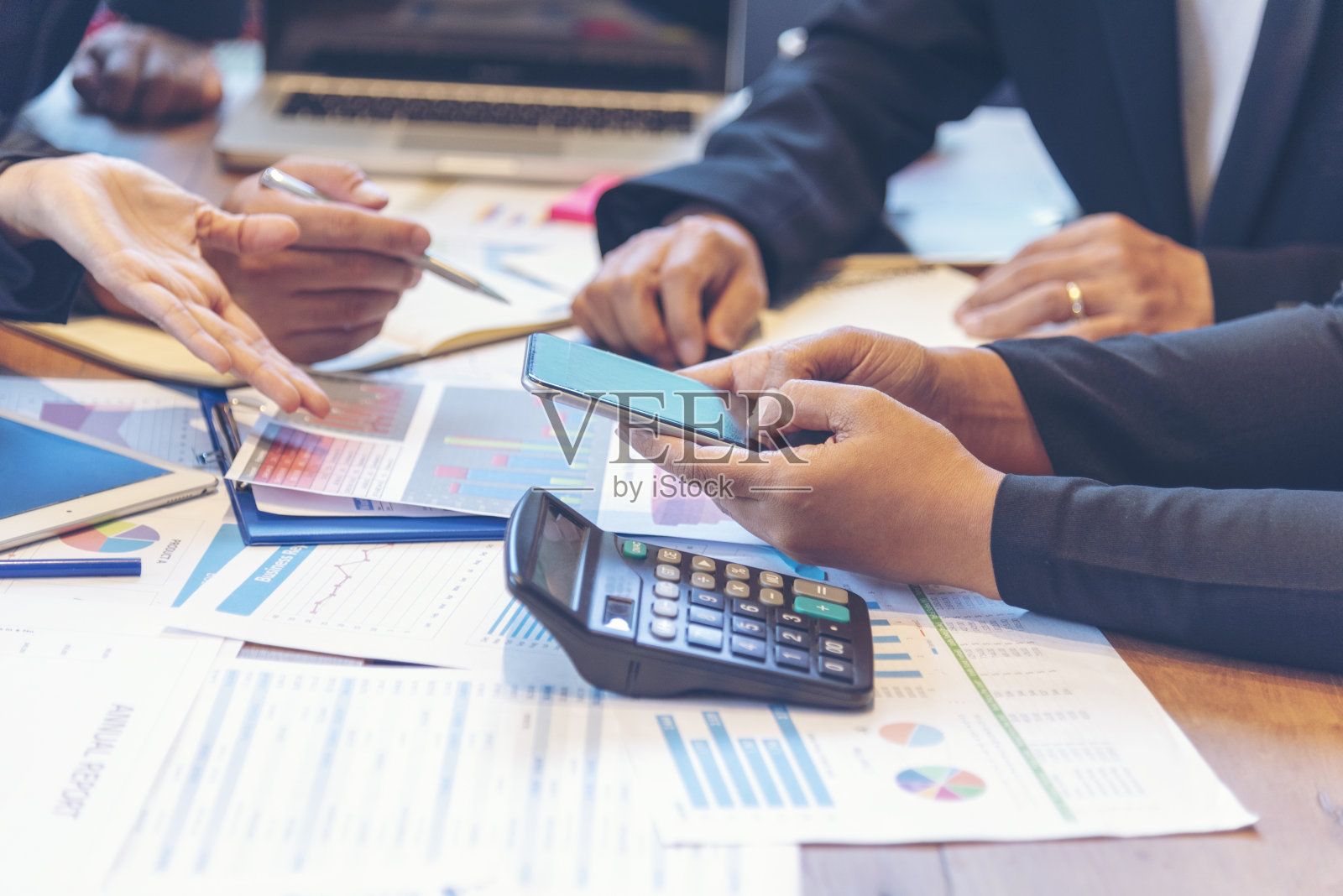 一群商务人士在会议室开会,头脑风暴,查阅商务文件,图表,办公桌。多样性,多种族的商业人士头脑风暴和一起工作。照片摄影图片