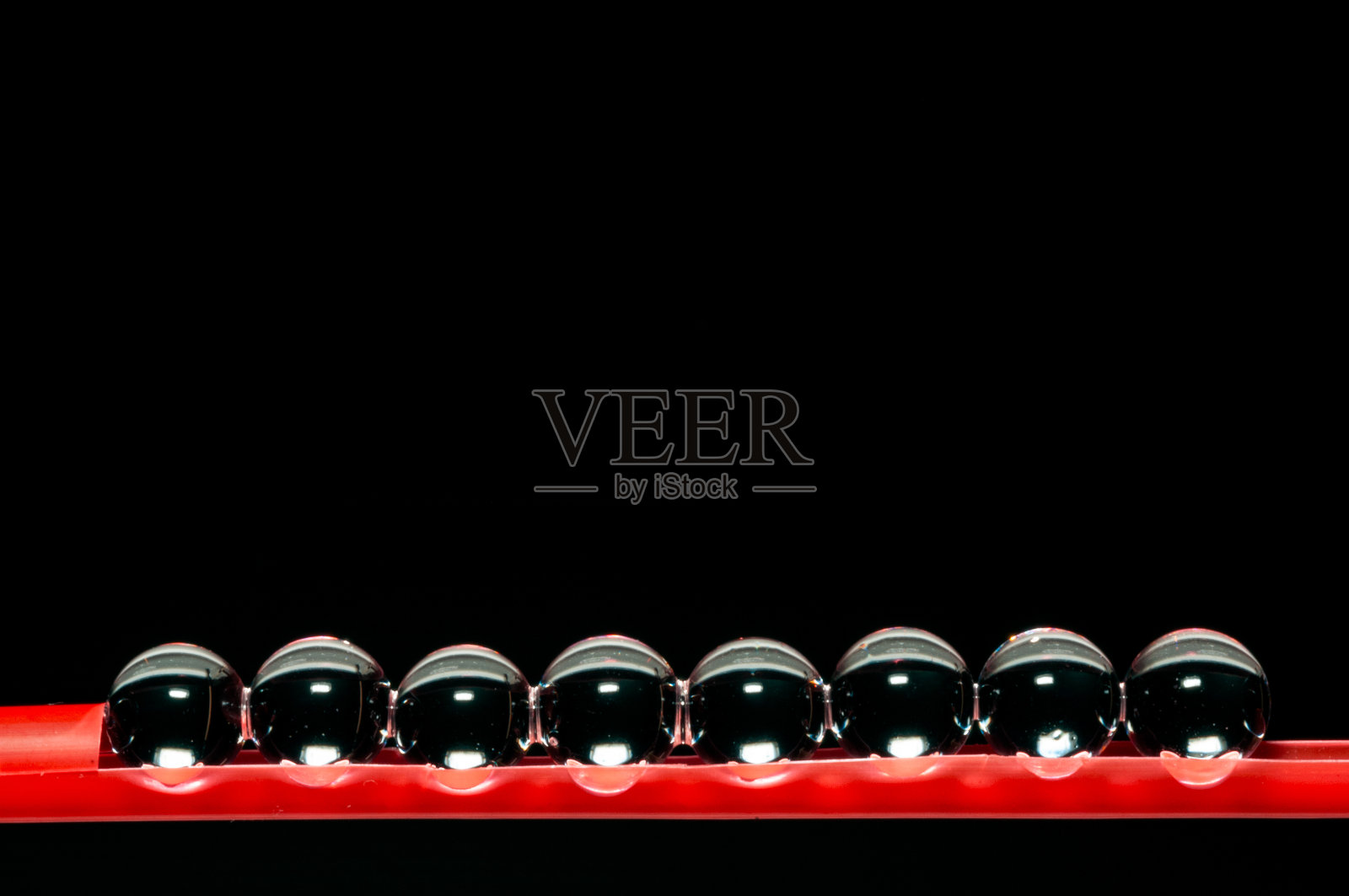 一组玻璃球在粉红色的塑料支持与复制空间在黑色的背景照片摄影图片