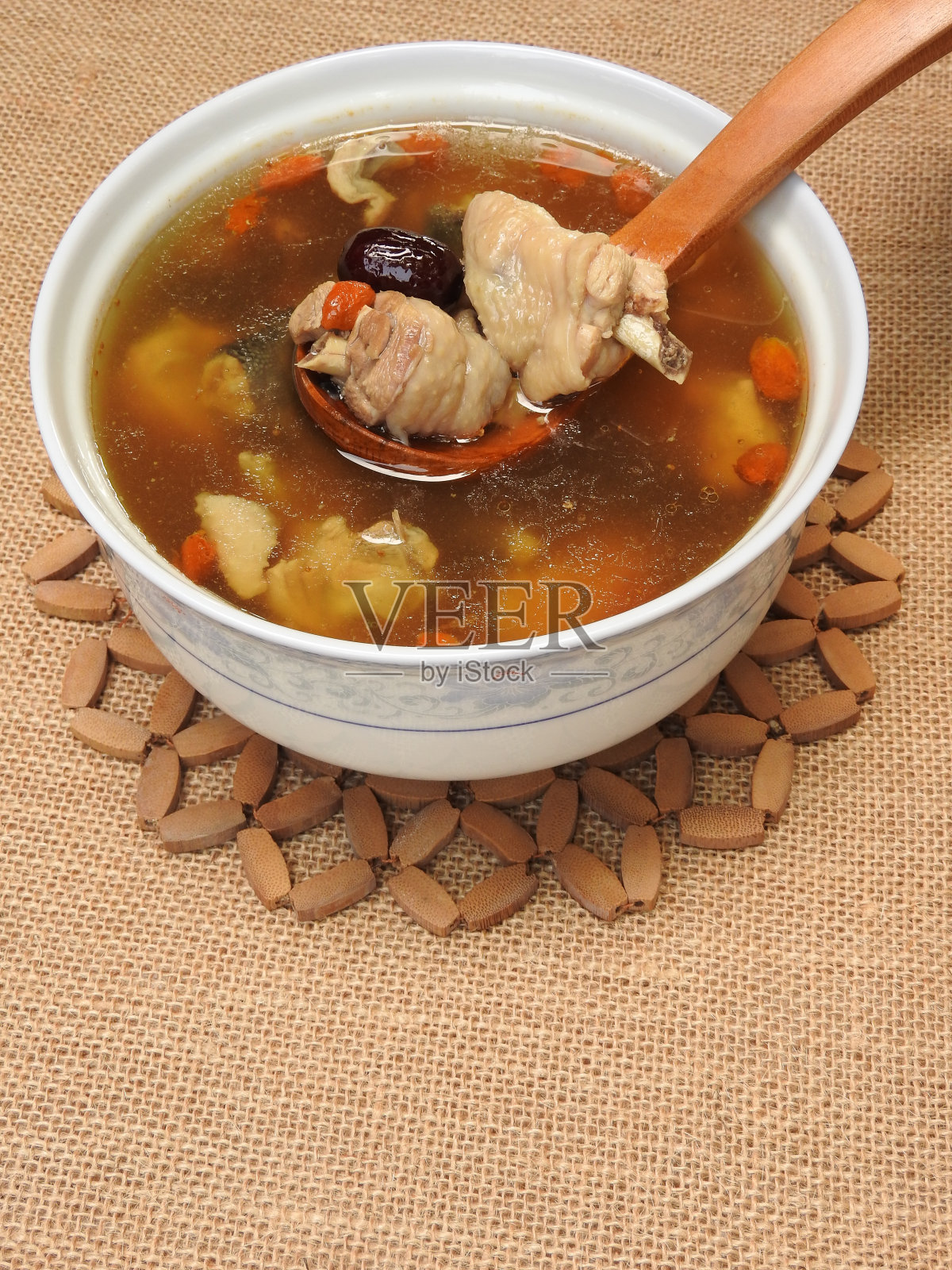 高角度的一碗鸡汤。它含有枸杞、红枣等中药。温暖,营养丰富。对健康有益。照片摄影图片