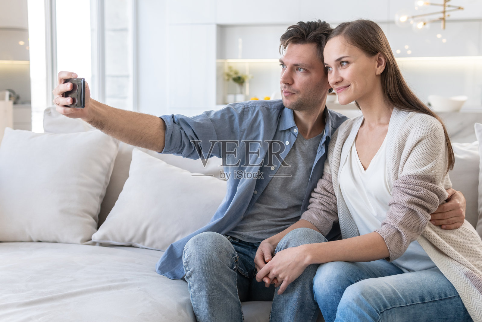 一对快乐的夫妇看着智能手机的屏幕照片摄影图片