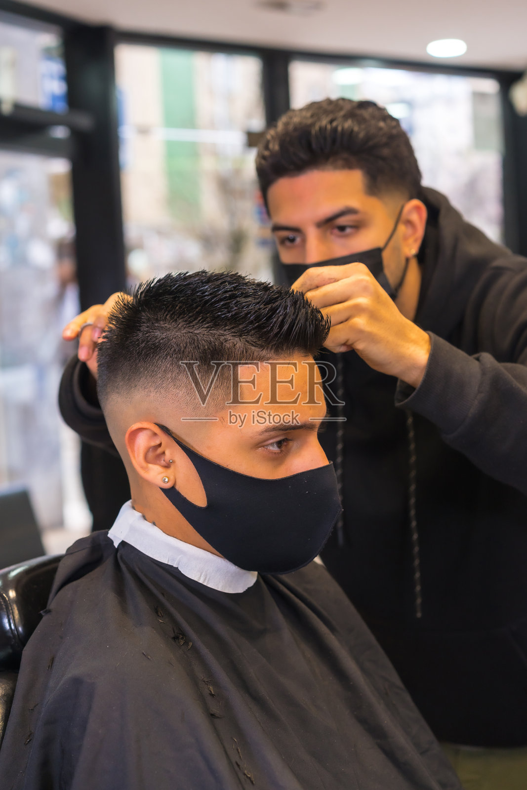 理发师用面罩理发。新冠肺炎疫情下的美发业新常态照片摄影图片