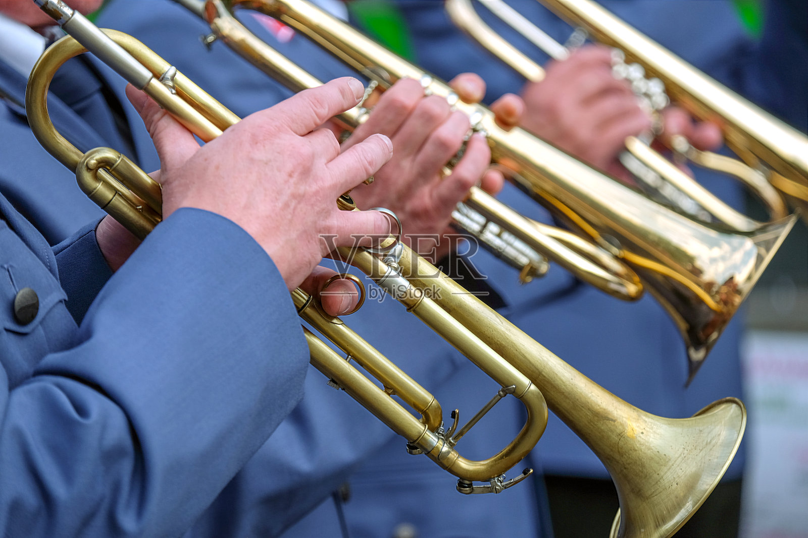 特写:身着制服的长号合唱团的音乐家们在音乐会中选择性地演奏小号照片摄影图片
