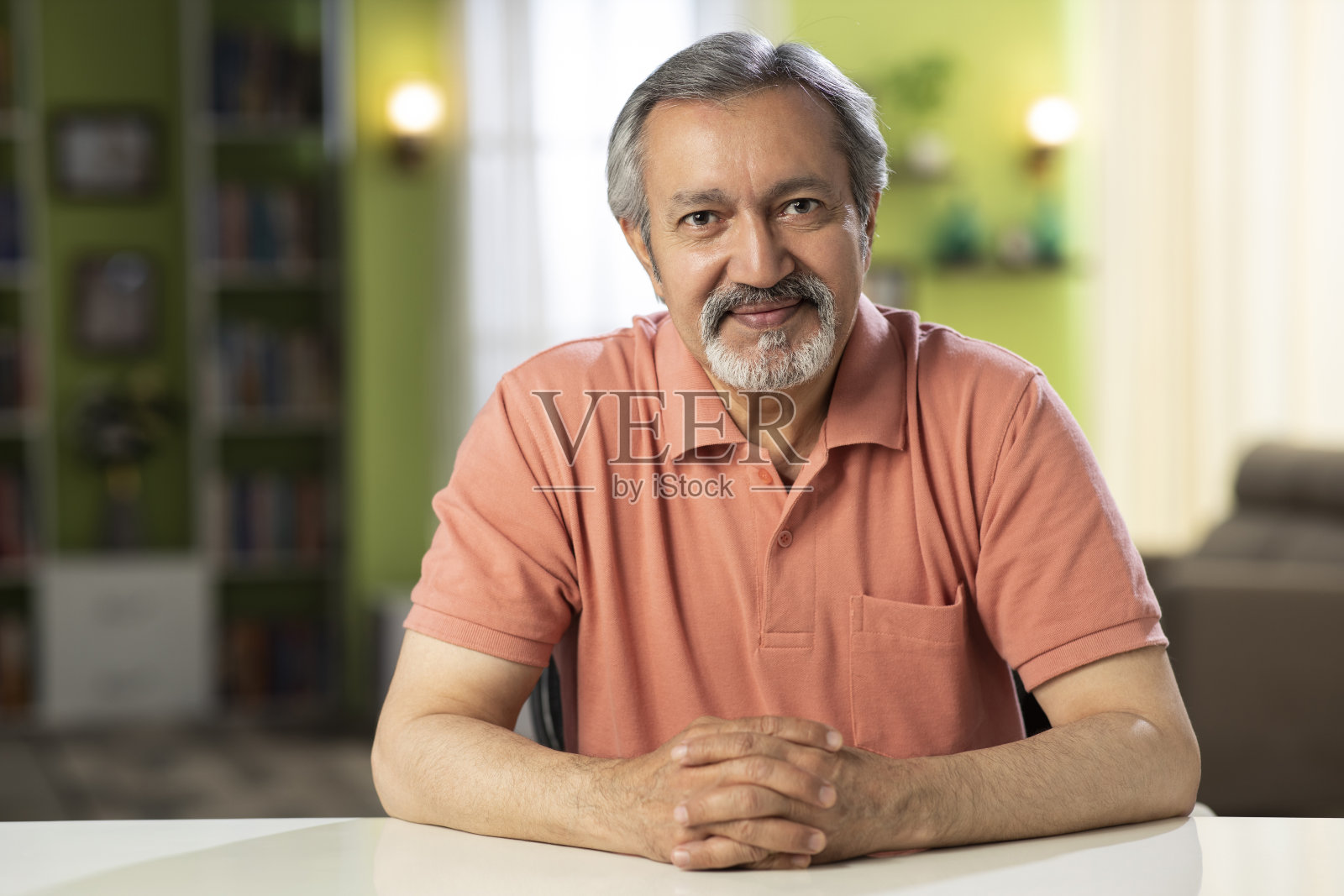 一个成熟男人坐在家里的椅子上的照片:-库存照片照片摄影图片