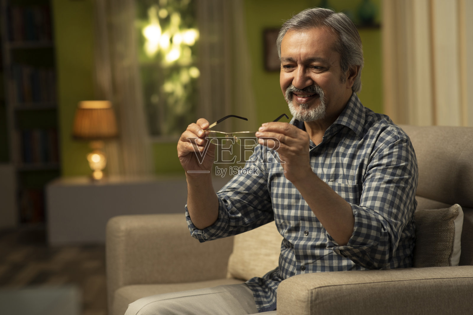 一个成熟的男人坐在沙发上的照片:库存照片照片摄影图片