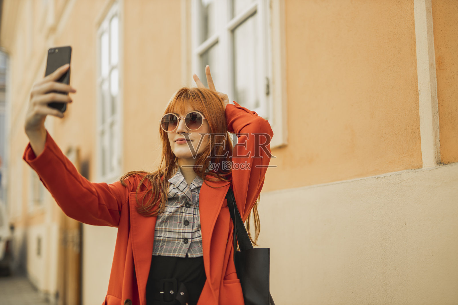 一位年轻女士在街上用手机照片摄影图片