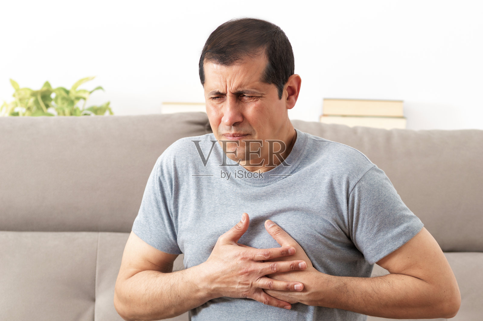 男人痛得捂着胸口照片摄影图片