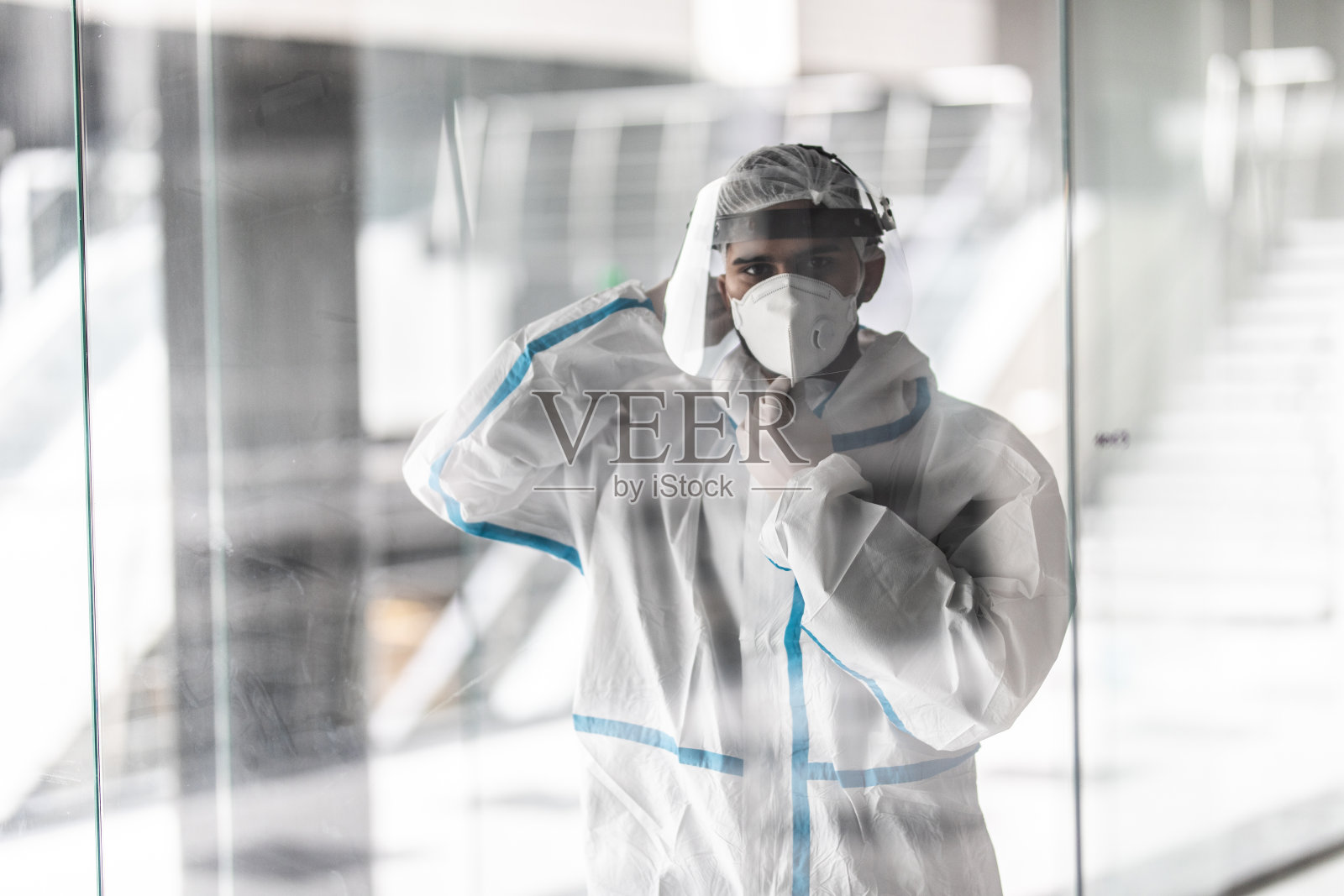 医生男子戴着外科口罩和面罩抗击冠状病毒爆发。卫生保健和医务工作者的理念照片摄影图片