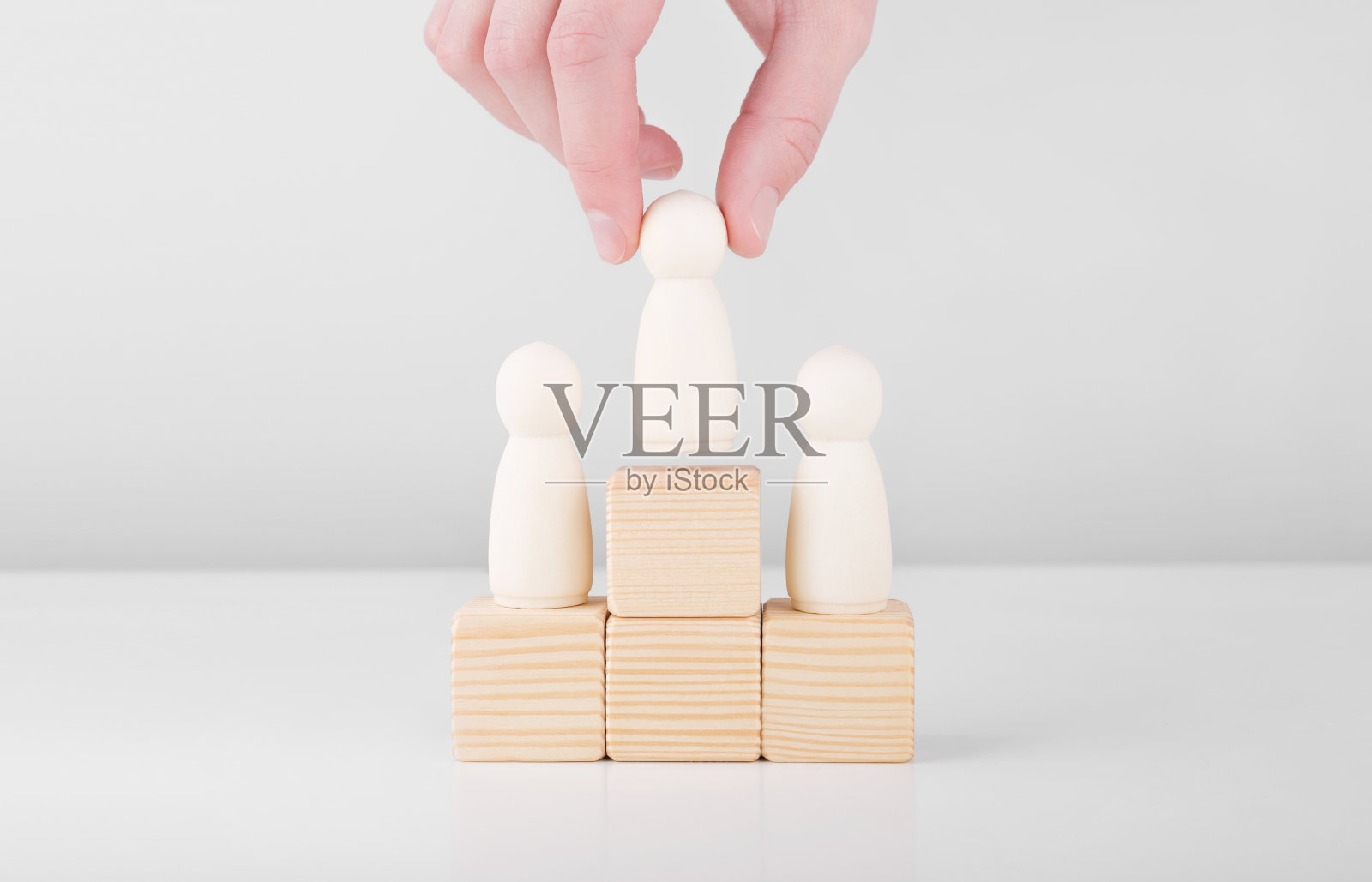 商人捧着代表领袖迈向成功的木人站在台上。领导与职业成长的概念。照片摄影图片