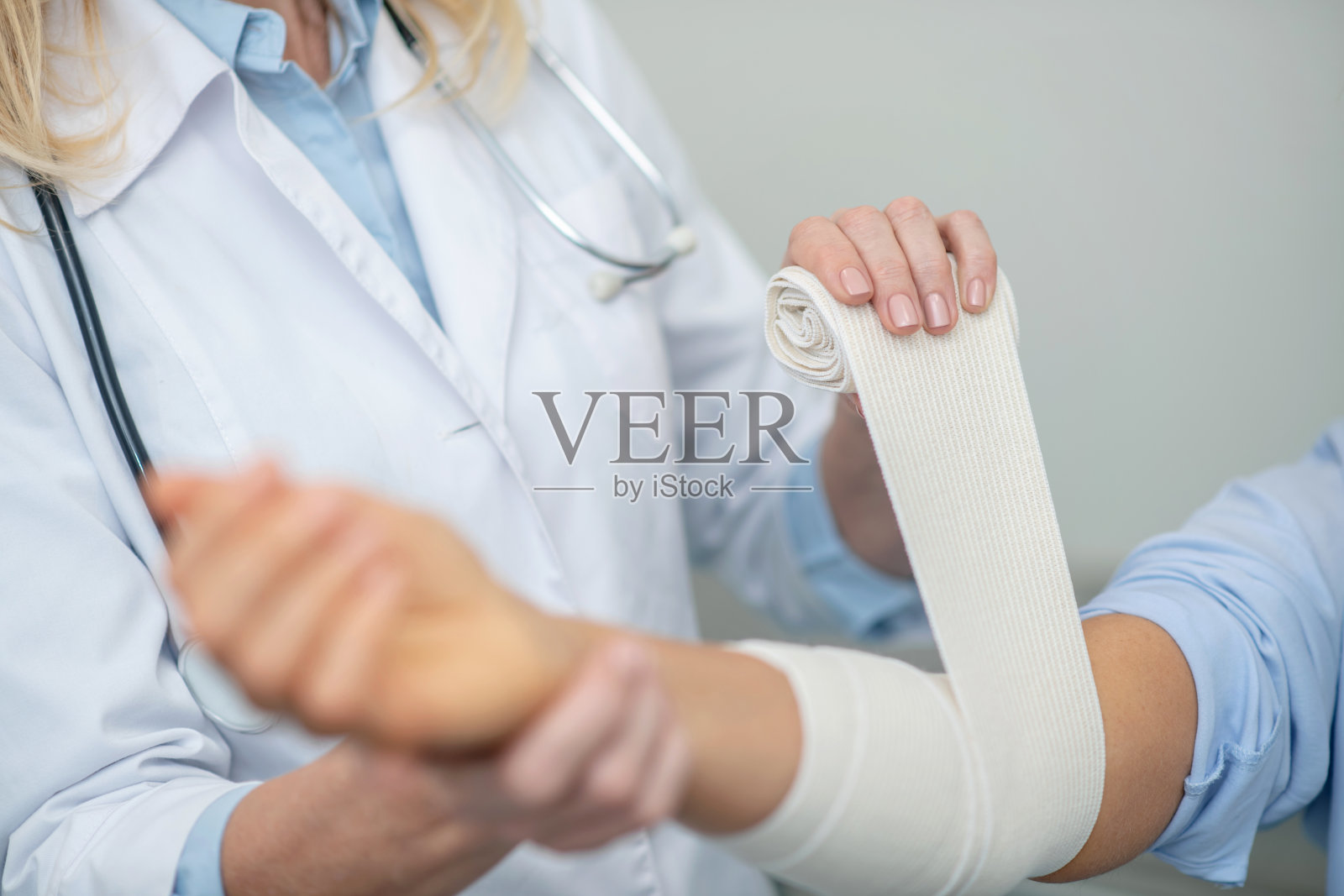 医务人员双手安全包扎受伤的前臂照片摄影图片