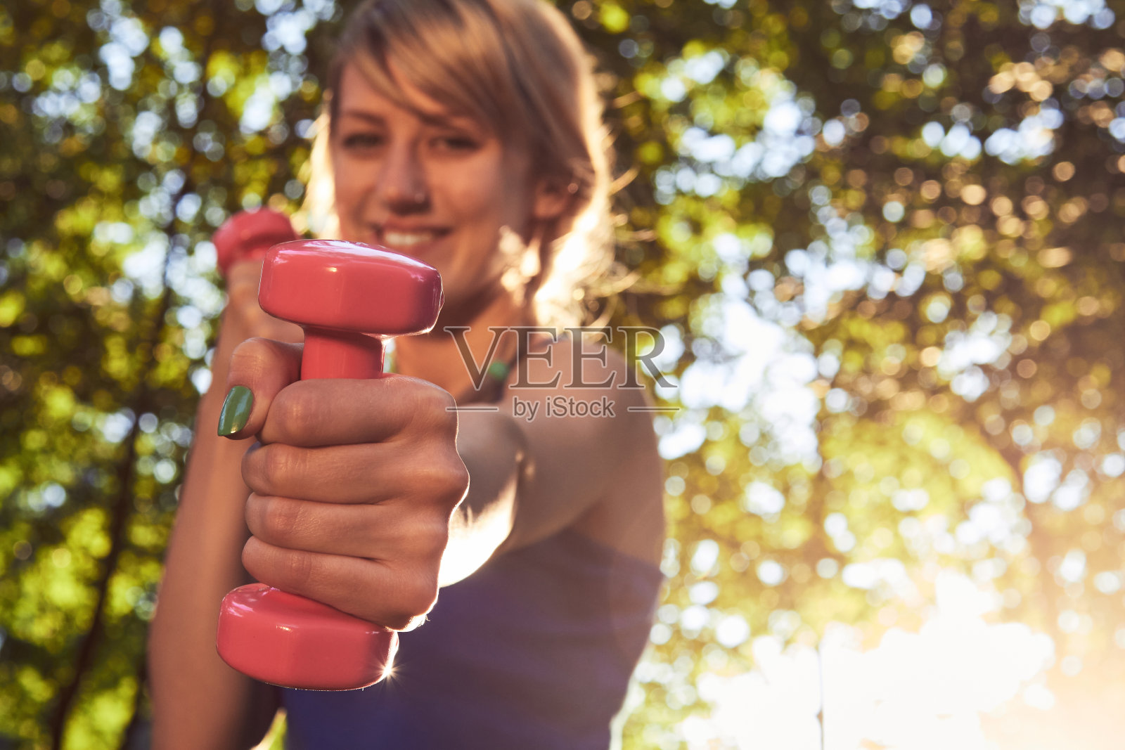 在公园里做小重量运动的女人。照片摄影图片