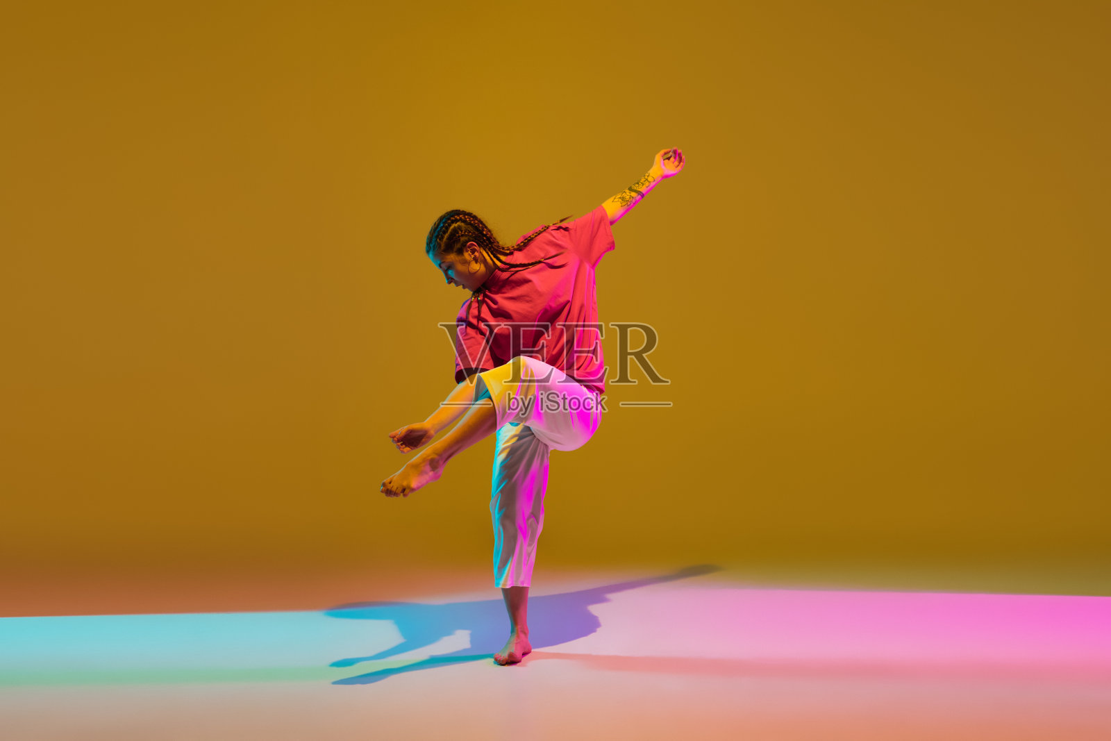 体育女孩跳舞嘻哈在红白衣服上霓虹灯的背景。照片摄影图片