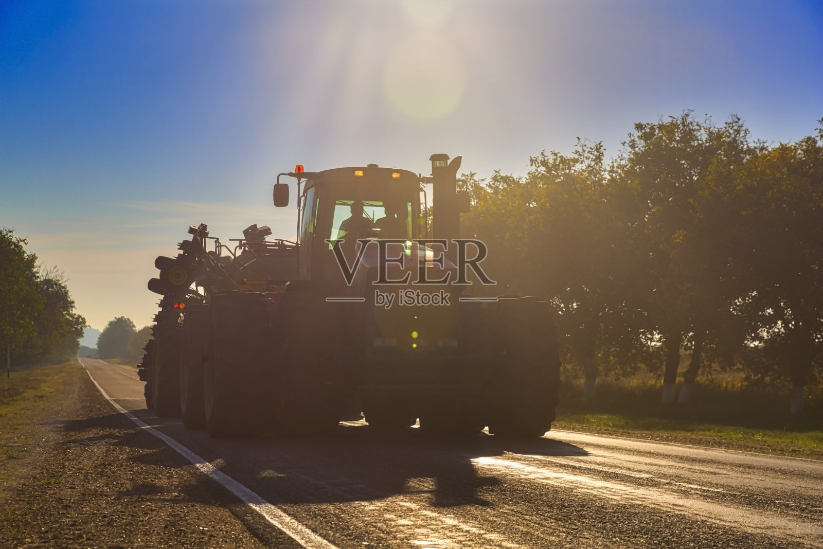 农用拖拉机收割完田地正返回路上照片摄影图片