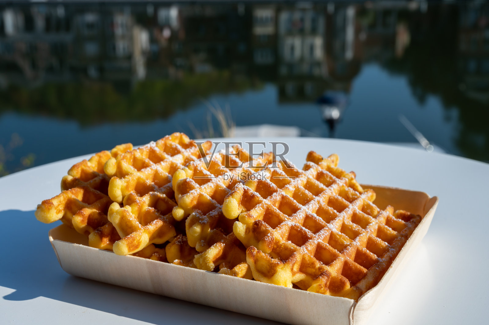 比利时瓦隆尼亚迪南市,新鲜出炉的比利时华夫饼在室外享用,可以看到马斯河的景色。照片摄影图片