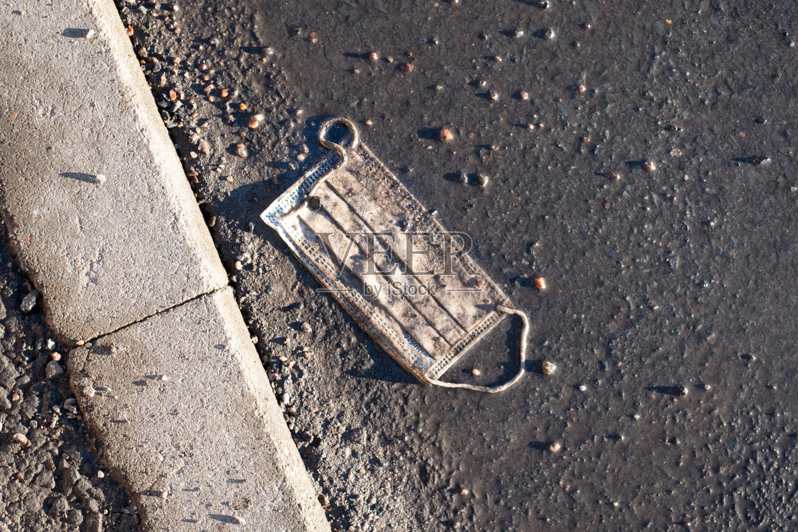 肮脏的外科口罩扔在大街上。疫情期间使用医用口罩躺在地上照片摄影图片