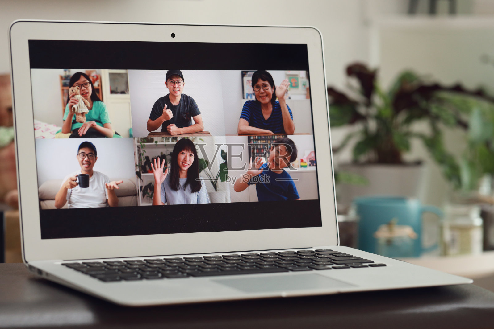 一名亚洲妇女在大流行封锁期间在家用笔记本电脑与家人进行视频会议照片摄影图片