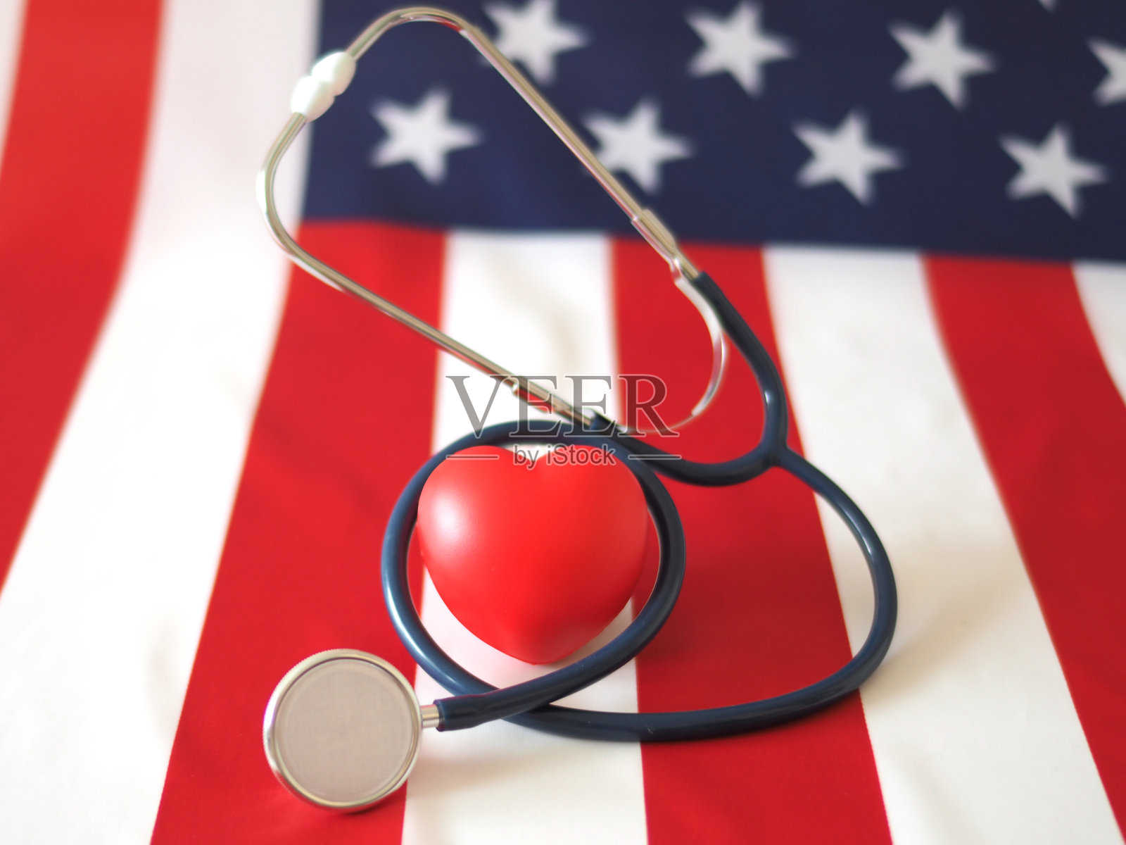 一颗带有旗帜背景听诊器的心脏。概念美国医疗保健和医药。照片摄影图片