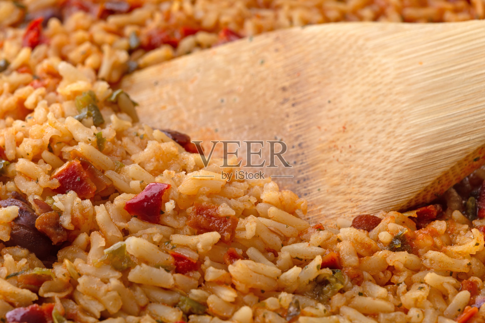 用木勺在平底锅里煮墨西哥米饭和豆子照片摄影图片