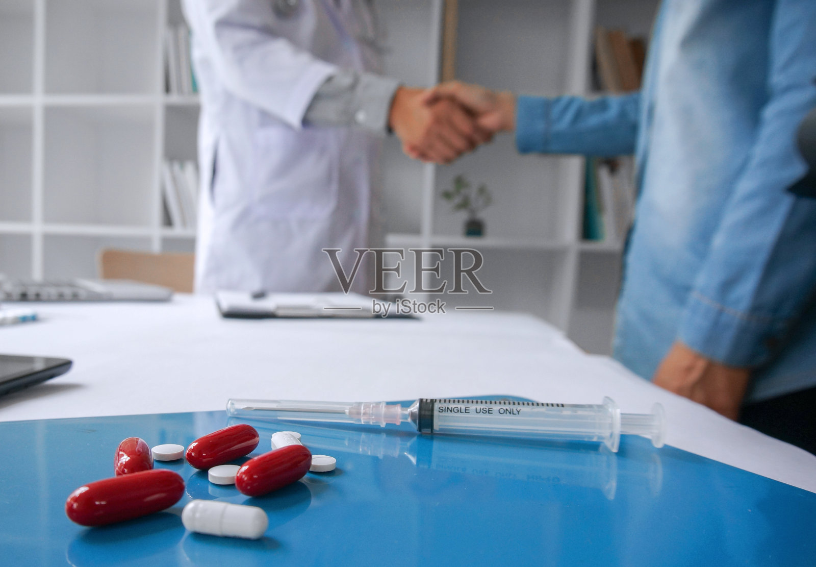 医生为病人手持一包不同的水泡片。规定药剂。疾病治疗的概念。药片和药片的包装放在桌子上。照片摄影图片