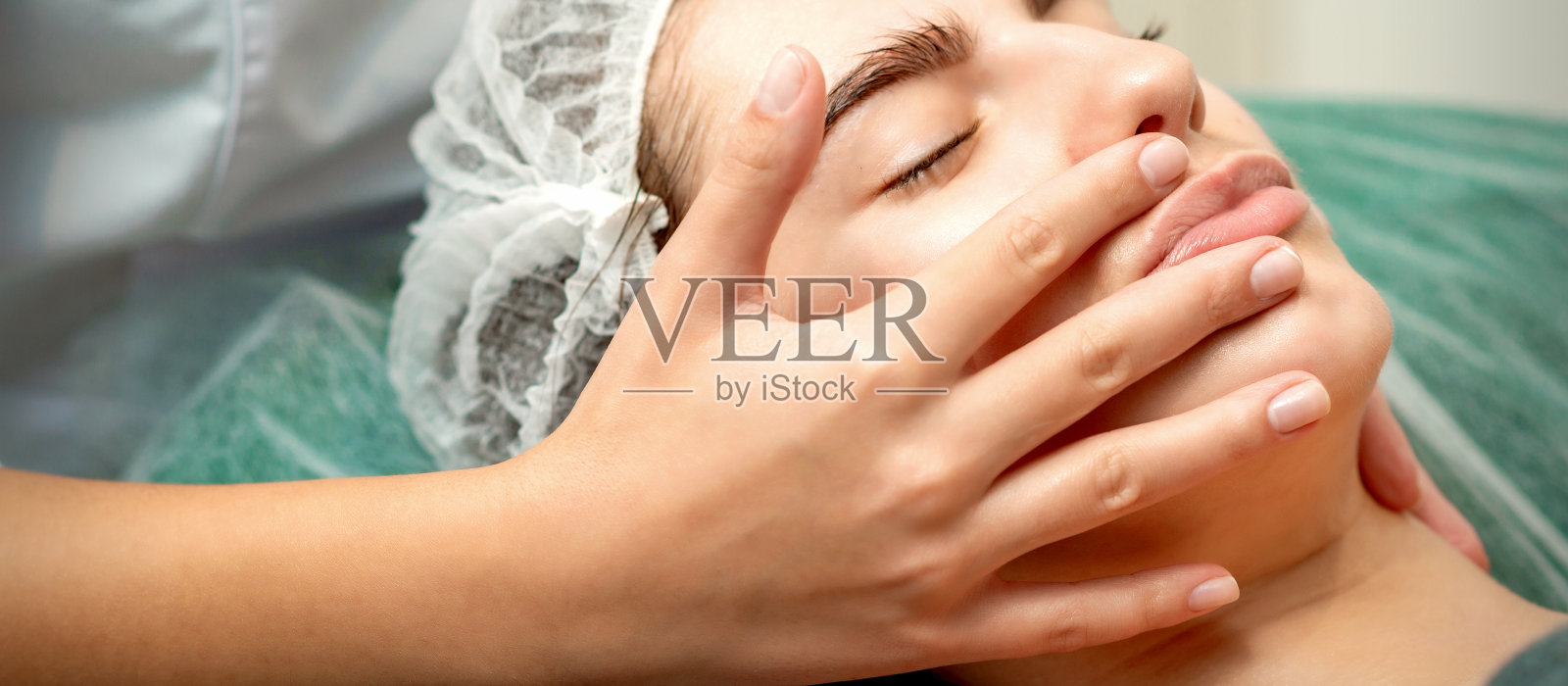 年轻女子正在接受面部按摩照片摄影图片