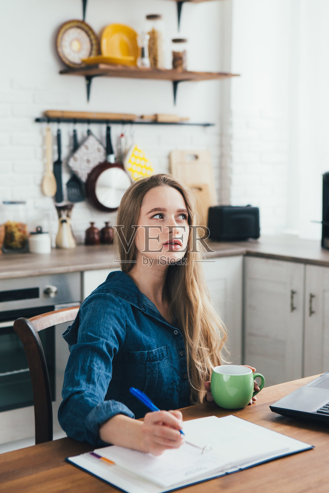 怀孕的女孩,一个自由职业者在家厨房工作照片摄影图片