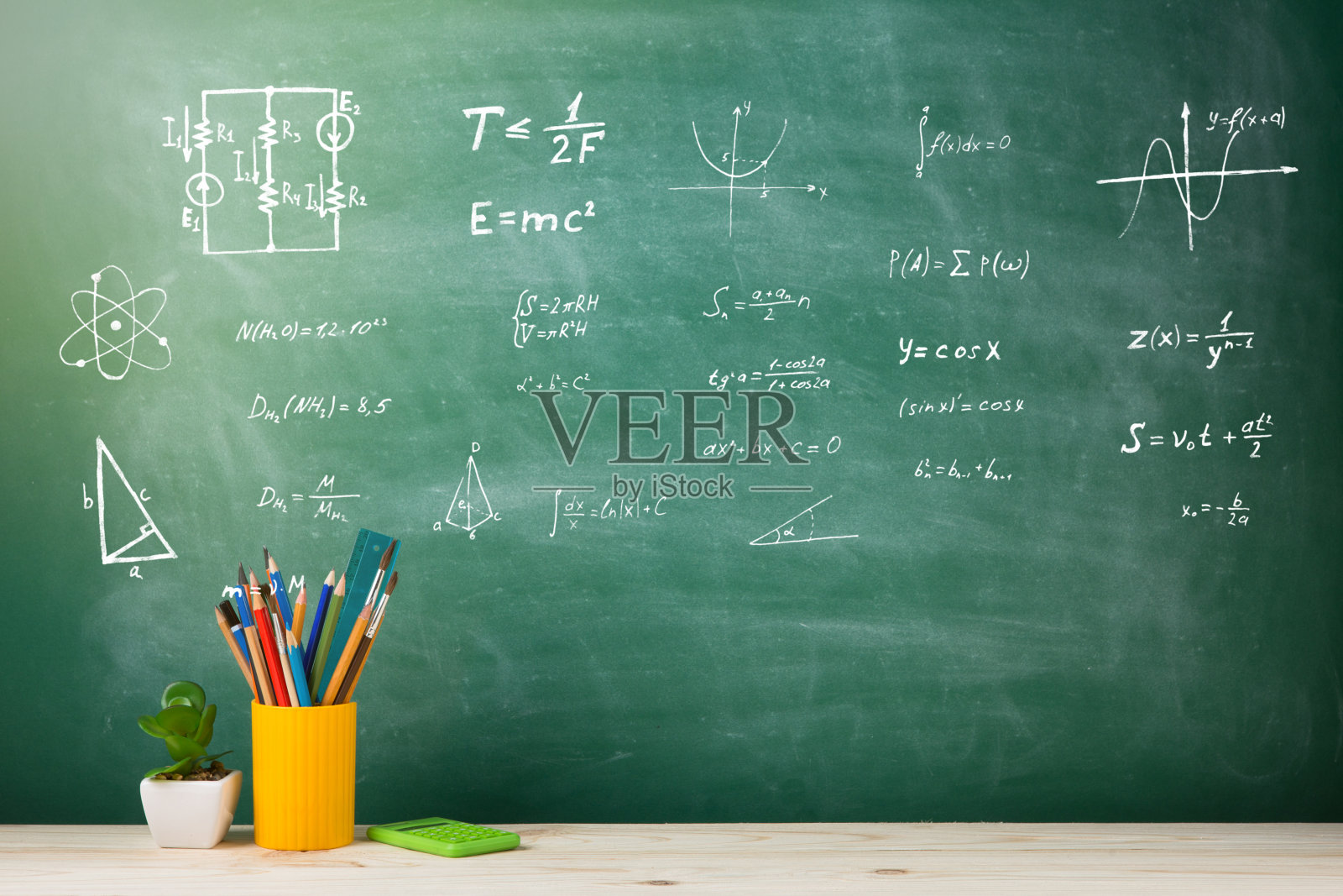 教育理念——学校用品在礼堂的课桌上,黑板为背景照片摄影图片