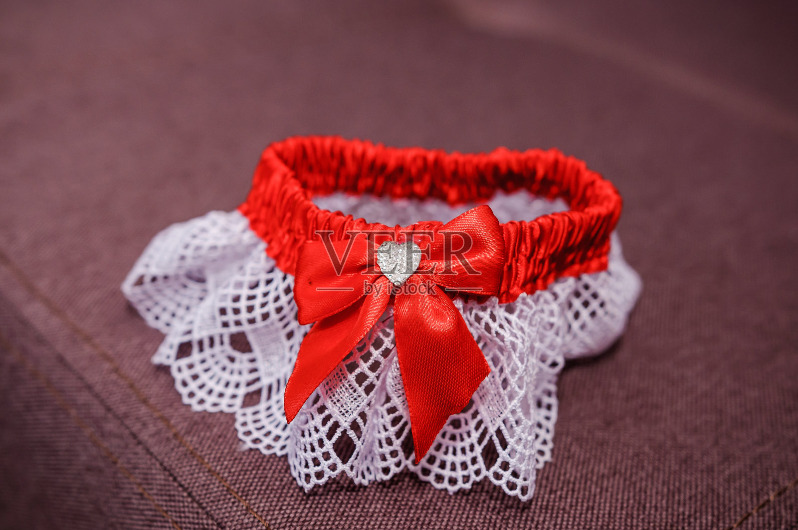 棕色背景上的红色新娘吊袜带照片摄影图片