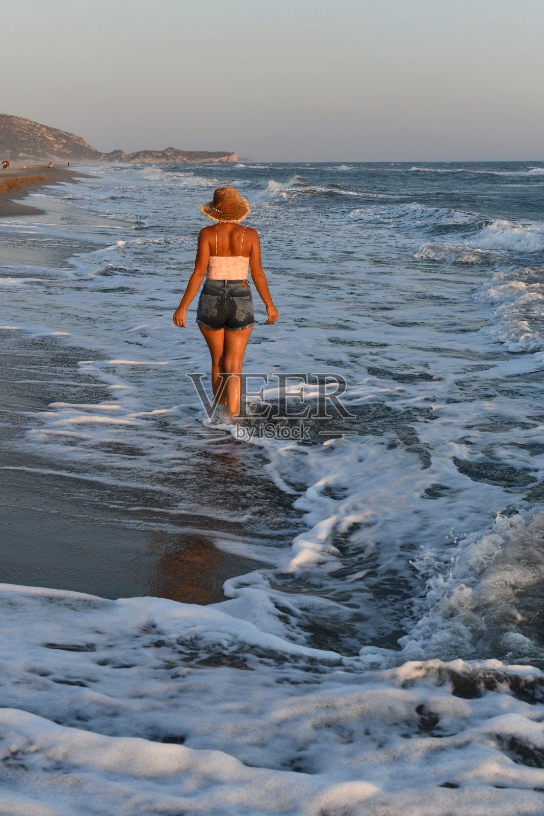 在海滩上玩得开心的女人。照片摄影图片