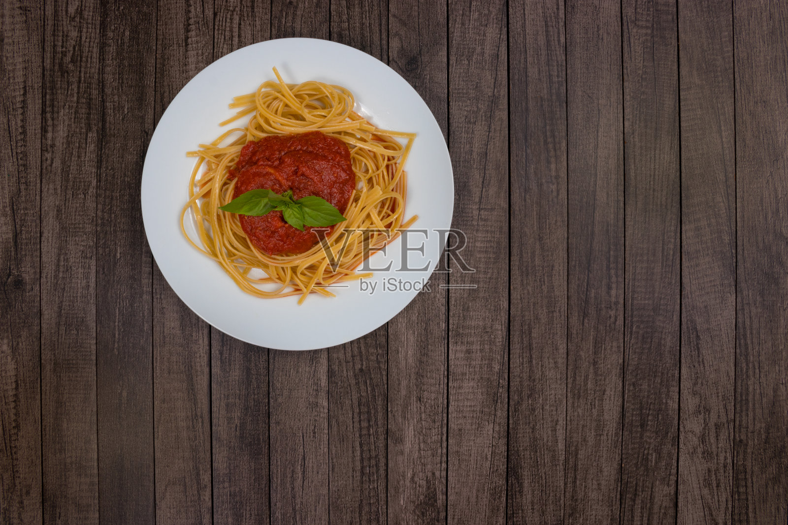 罗勒叶苏戈酱意大利面。顶视图的照片。典型的意大利食品。红酱意大利面。Bavette面条照片摄影图片