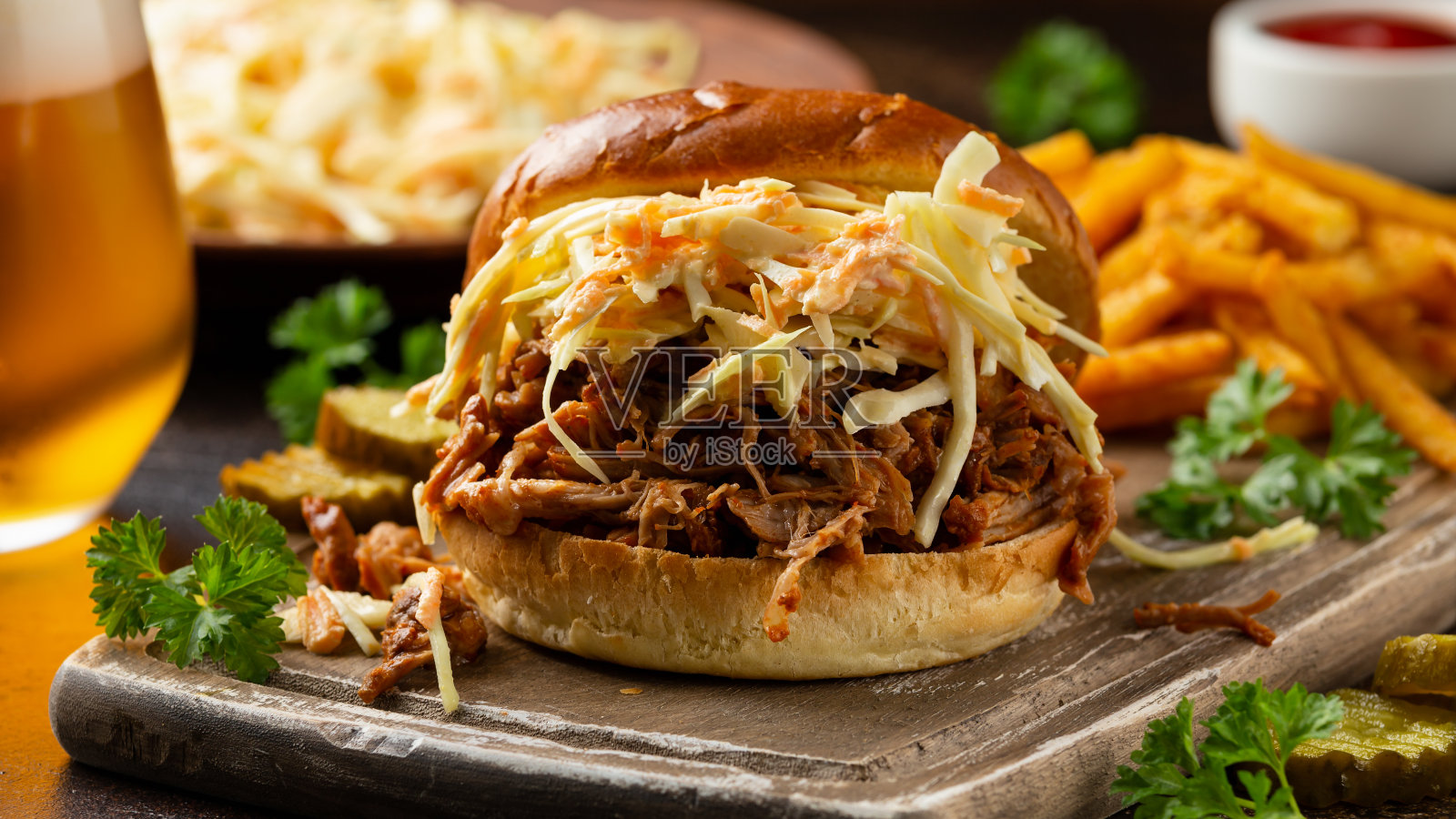 自制烧烤猪肉汉堡配卷心菜,薯条和啤酒照片摄影图片