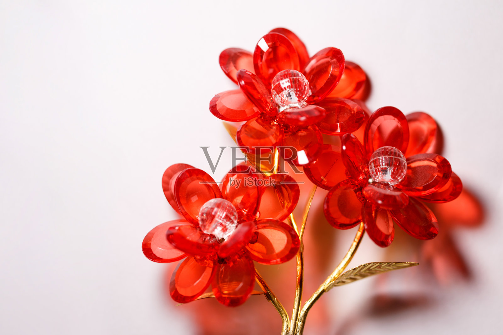 传统美丽的红花玻璃装饰品。放大照相。白色背景上的水晶花。装饰。副本的空间。平躺照片摄影图片