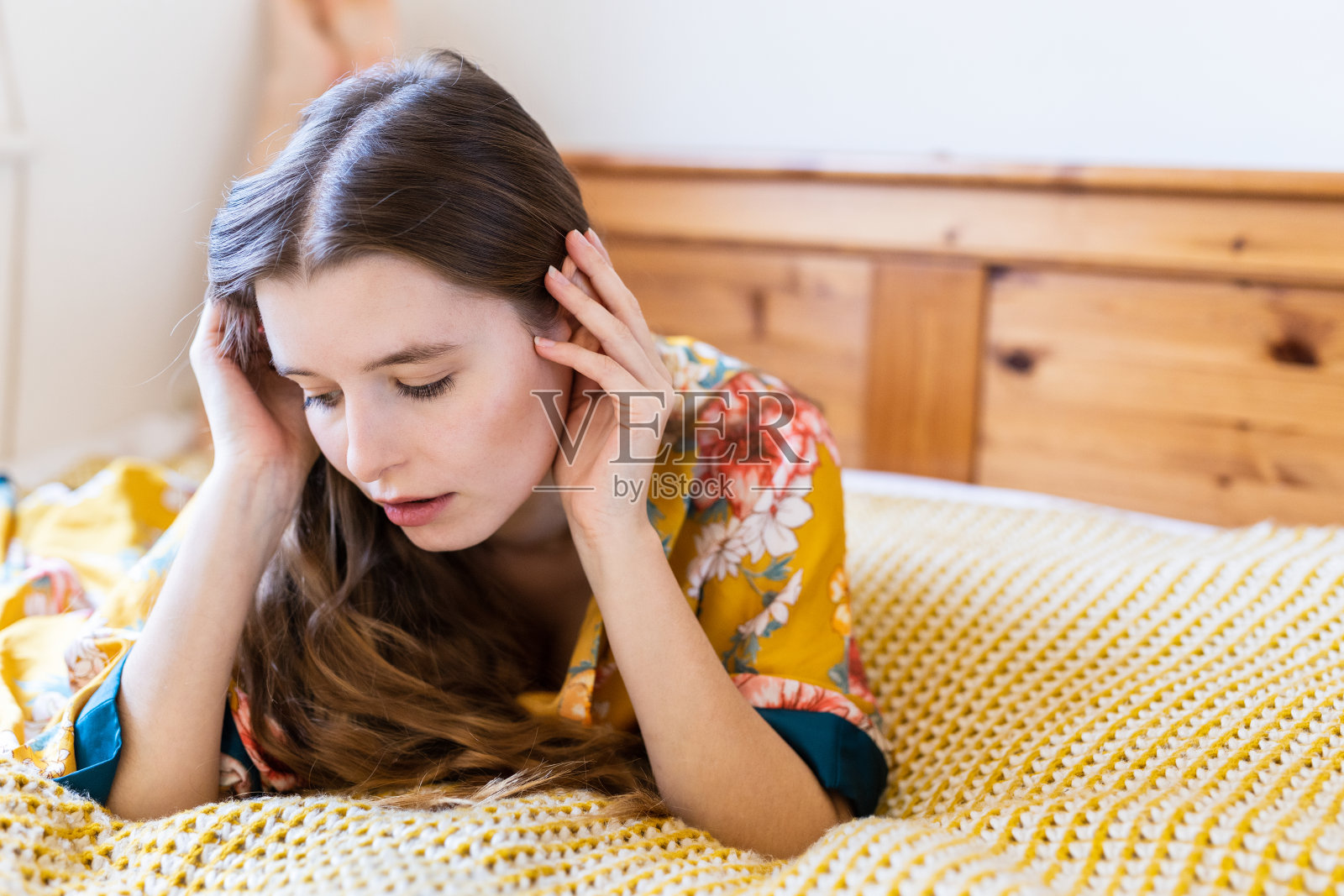 一个金发碧眼的年轻女子躺在床上,望着远方照片摄影图片