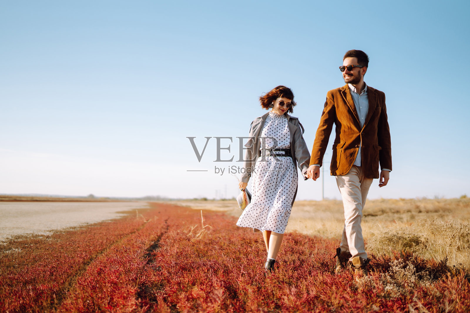 春天的时候,一对年轻夫妇在公园里散步,互相拥抱。享受在一起的时间。青春、爱情、生活方式的概念。照片摄影图片