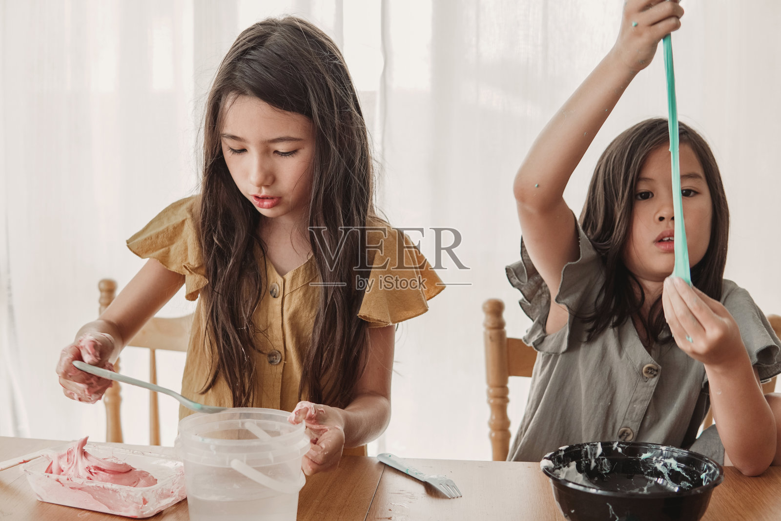 快乐混合亚洲女孩朋友自制黏液玩具,感官艺术和工艺,有趣的家庭学校化学项目照片摄影图片