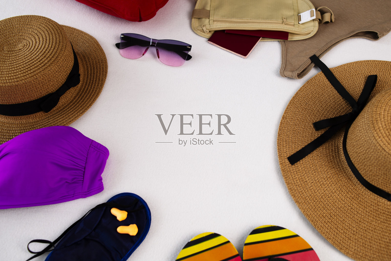 护照放在皮带袋里。人字拖、安全护目镜和草帽、飞机充气枕头、飞行用睡眠面罩和耳塞、带复印空间的旅行泳衣照片摄影图片