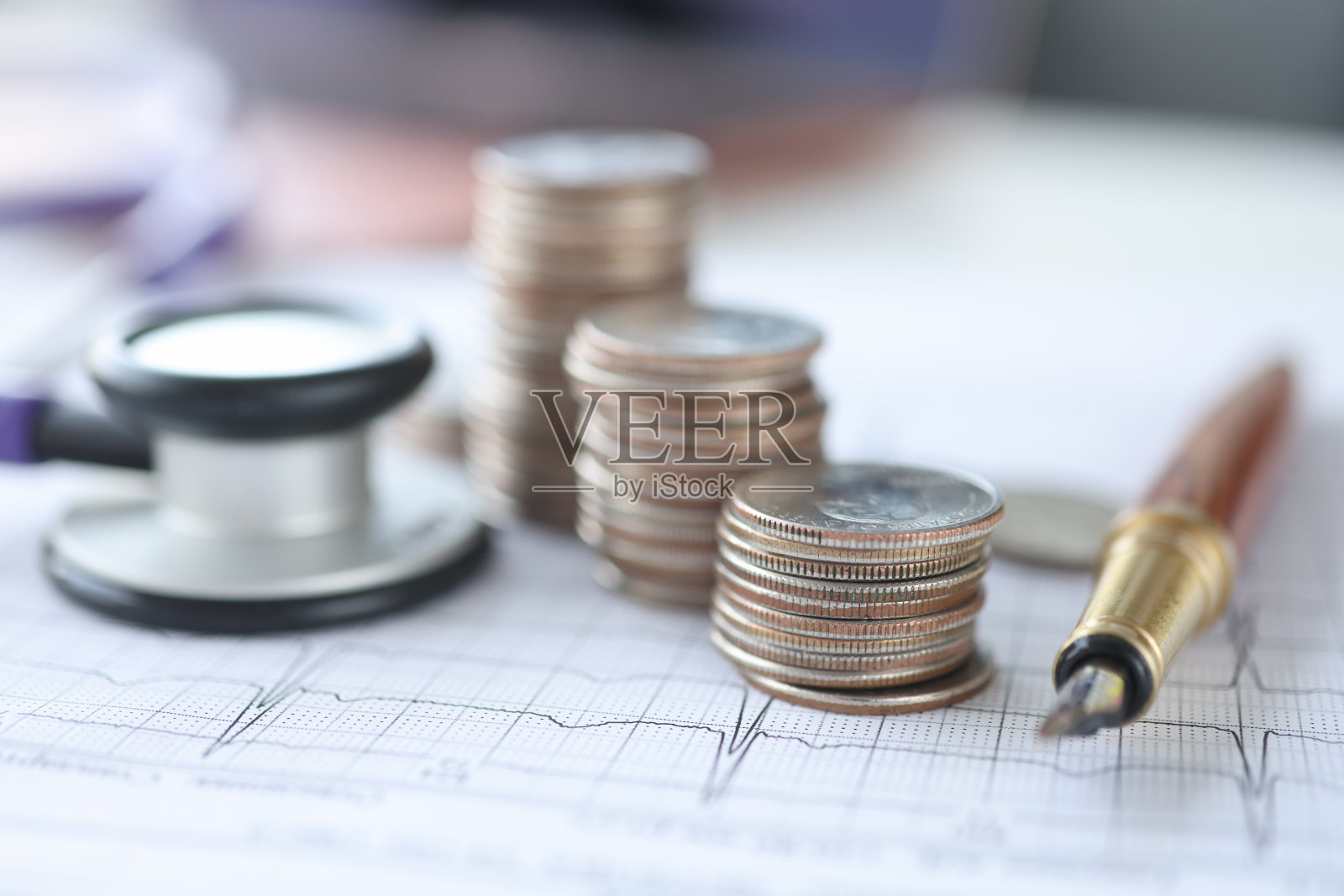 心电图听诊器和硬币放在桌子上照片摄影图片