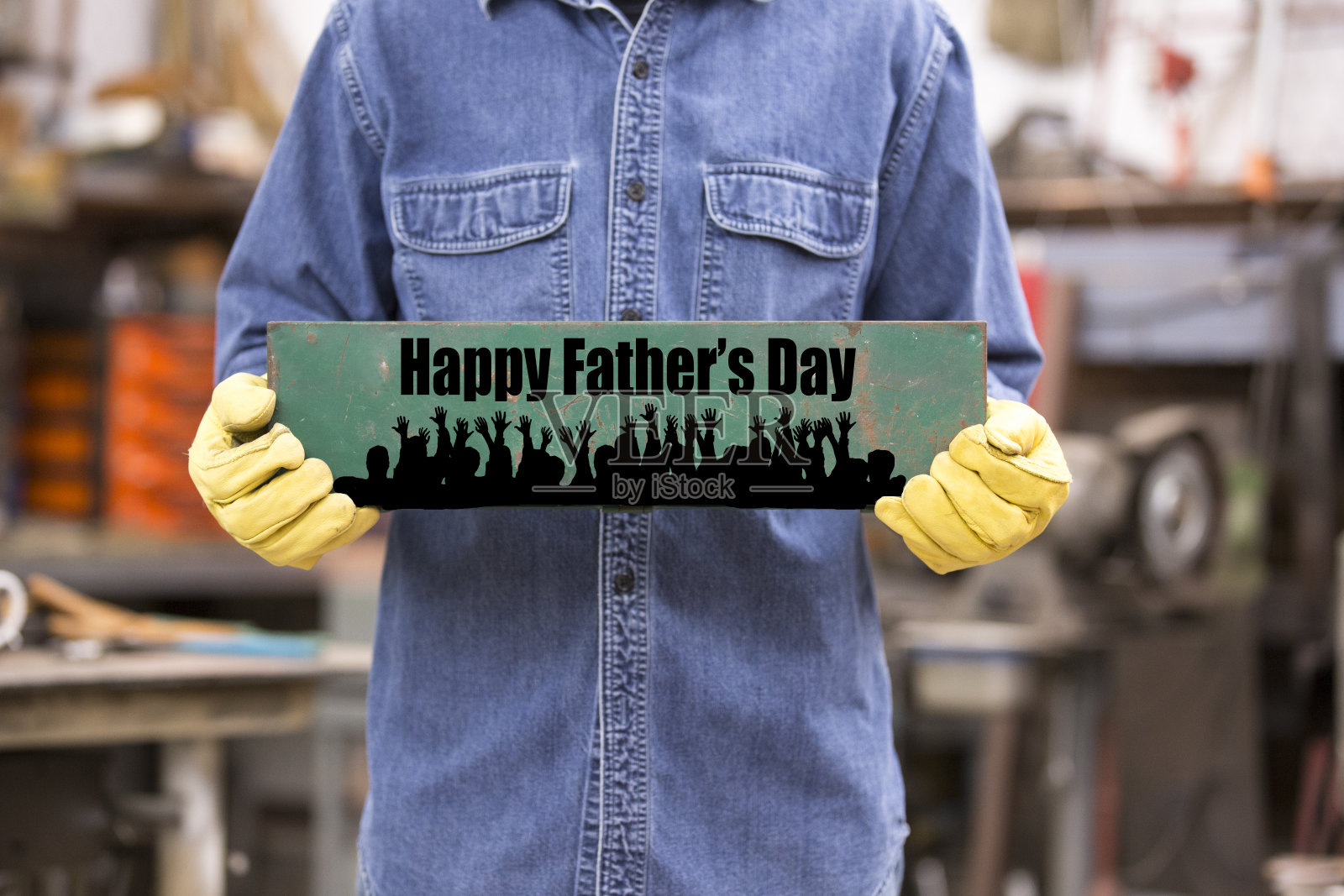 蓝领工人戴着工作手套举着“父亲节快乐”的牌子。照片摄影图片