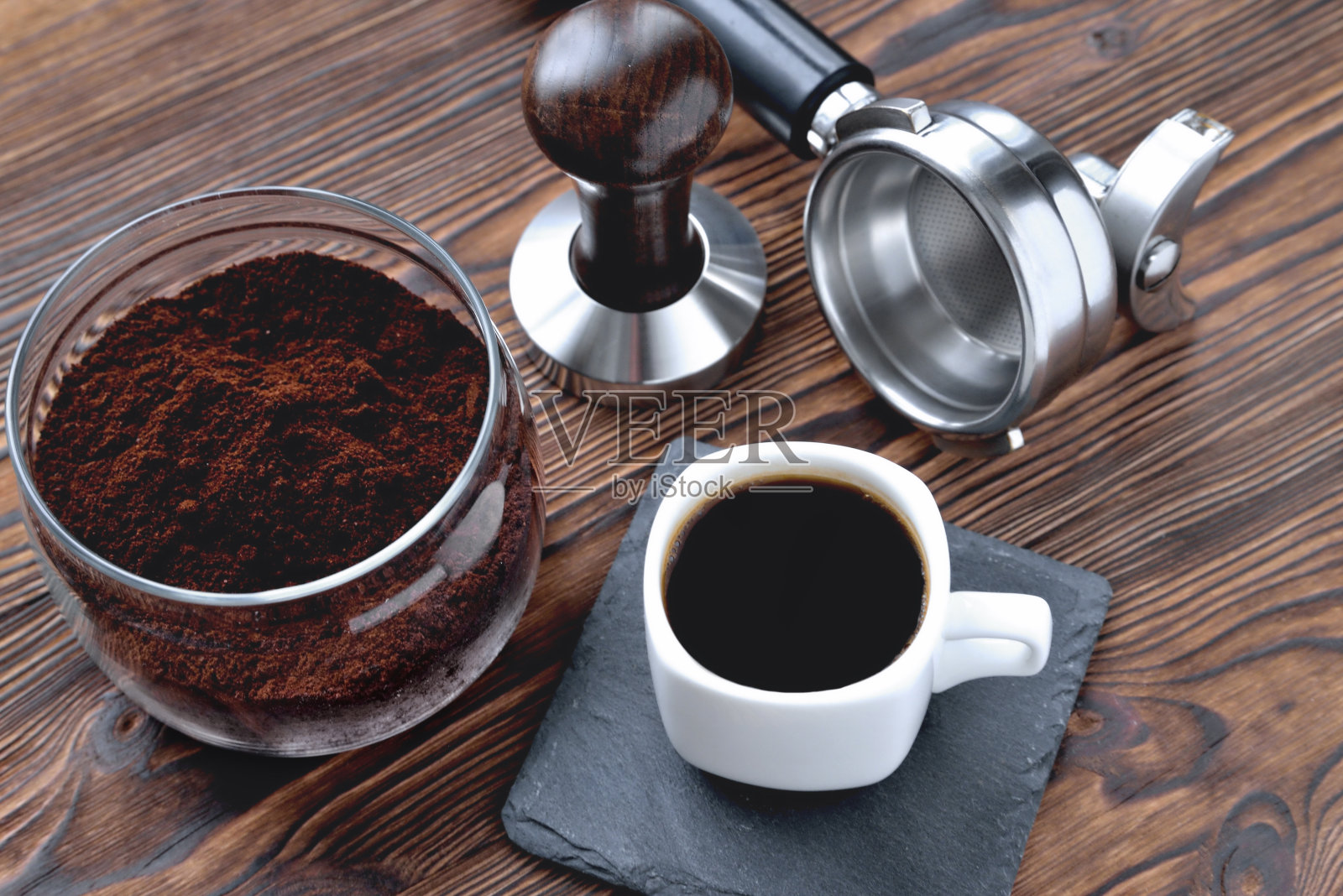 咖啡放在一个石头架子上的杯子里,一个玻璃罐,里面有咖啡和咖啡配件蛋彩画和一个咖啡机角,木制的自然背景,特写空间为一个复制空间照片摄影图片