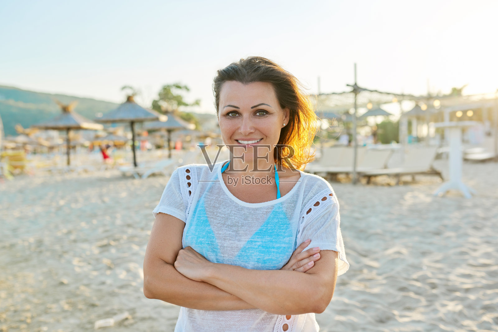 快乐微笑自信的中年妇女在海滩上的肖像照片摄影图片