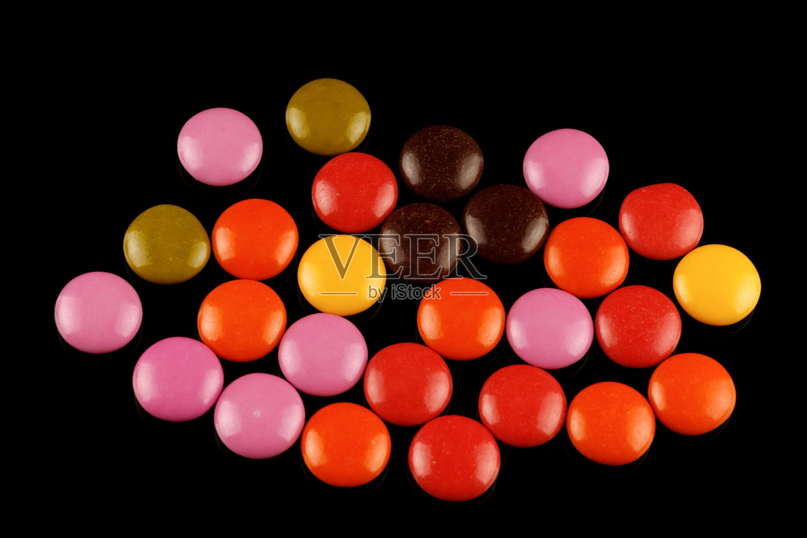黑色背景上的彩色圆形巧克力或口香糖照片摄影图片