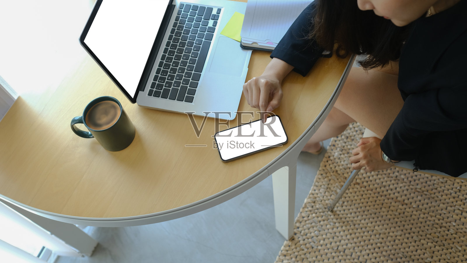 头顶拍摄的女商人坐在她的工作场所和使用智能手机。照片摄影图片