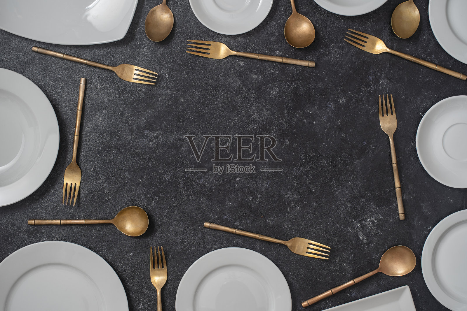 许多白色空白陶瓷盘子和黄铜叉子和勺子在黑色背景与复制空间的文本照片摄影图片