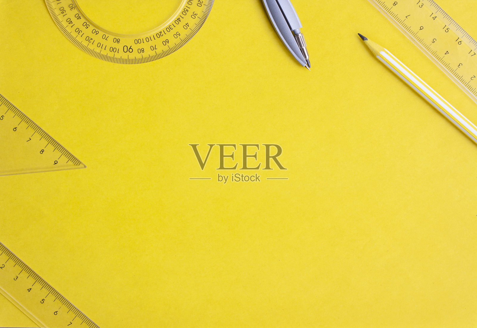 平放尺子,圆规和铅笔在黄色背景,复制空间照片摄影图片